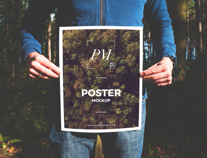 Man-in-Forest-Holding-Poster-Mockup-PSD